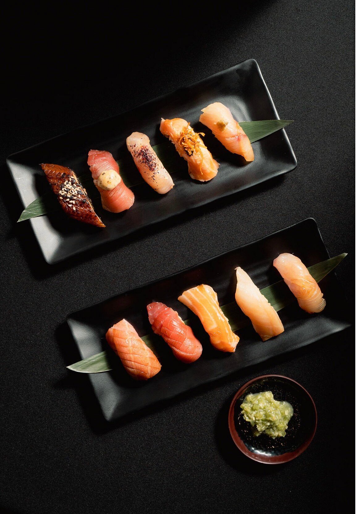 Dos platos de nigiri surtido con salsa verde