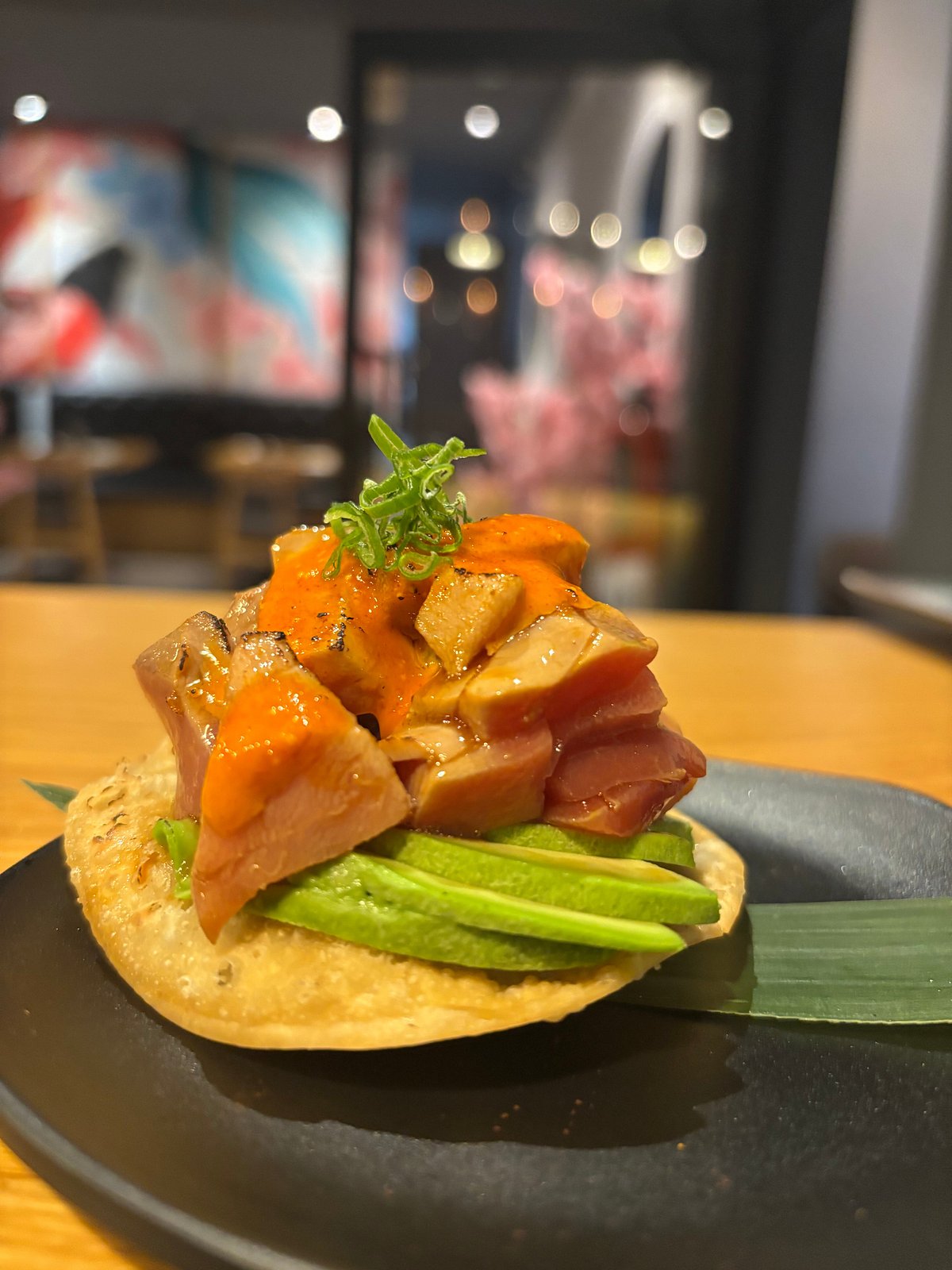 Tostada con cubos de pescado y láminas de aguacate